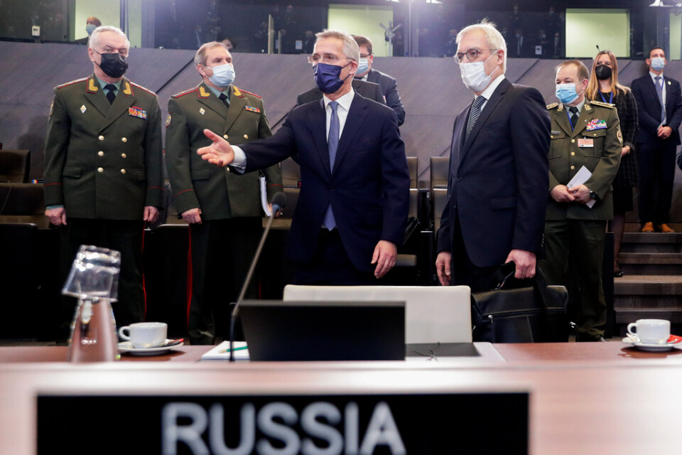 Natos generalsekreterare Jens Stoltenberg (mitten) visar Rysslands biträdande utrikesminister Aleksandr Grusjko och företrädare för det ryska försvarsdepartementet var de ska sitta vid onsdagens möte i Bryssel.