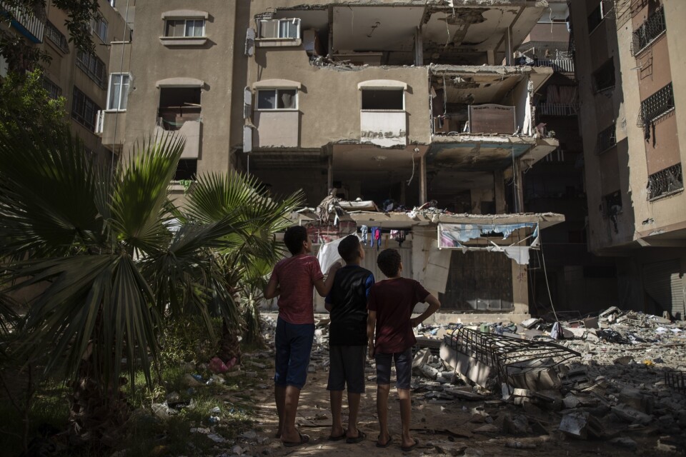 Palestinier i flyktinglägret Shati i Gaza betraktar byggnaden som bombades av Israel. Tio människor dödades i attacken.
