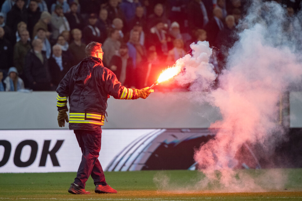Personal tar hand om en inkastad bengal under skandalmatchen mellan Malmö FF och Union Berlin. Arkivbild.
