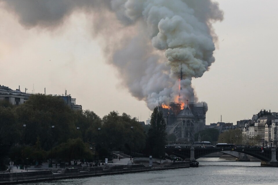Rök stiger från medeltidskatedralen Notre-Dame i Paris.