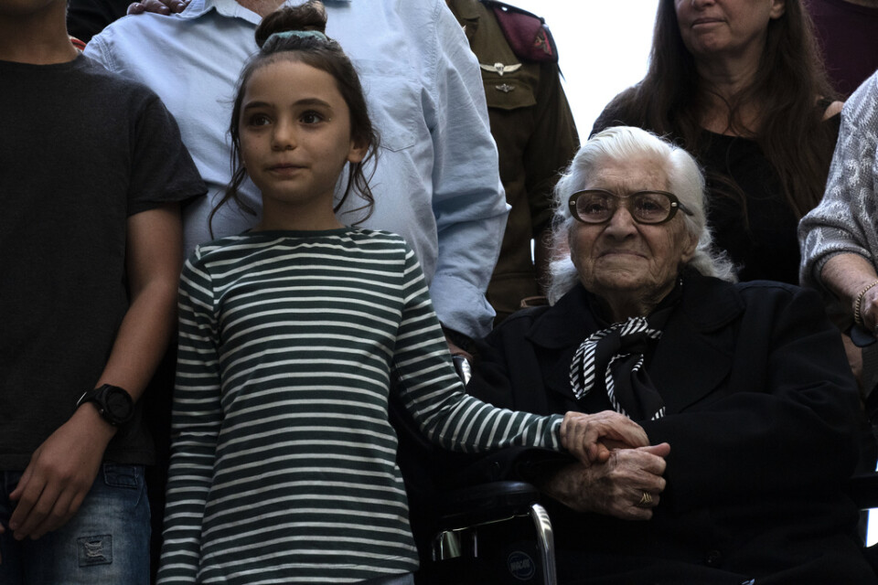Melpomeni Dina håller en israelisk flicka i handen vid återföreningen med de judiska syskon som hon räddade under andra världskriget.