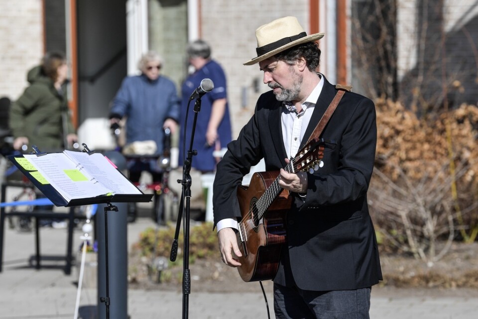 Trubaduren Mikael Edfelt underhåller med en utomhuskonsert på Attendos äldreboende i Täby.
