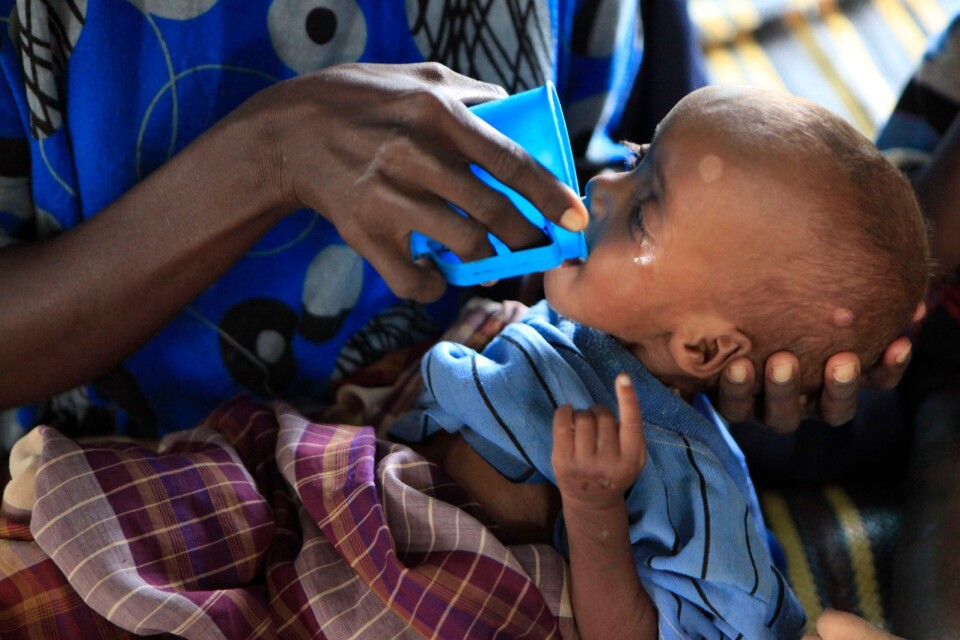 Marwo Maalin matar sin dotter, ettårige Habibo Bashir, som del i behandling för grov undernäring utanför Dadaab, Kenya, 2011. Östafrikas torka hotar somaliska barn och hundratals av dem har lämnats för att dö på den långa, torra resan till världens största flyktingläget i Dabaad i norra Kenya. UNICEF kallade torkan och flyktingkrisen ”den värsta humanitära krisen i världen”.