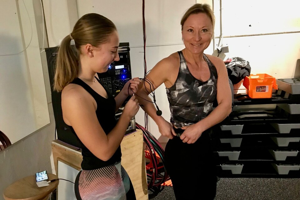 Jenny Sjöström får hjälp av sin dotter Johanna Sjöström. Mikrofonen måste sitta på ordentligt för en träningspassledare.