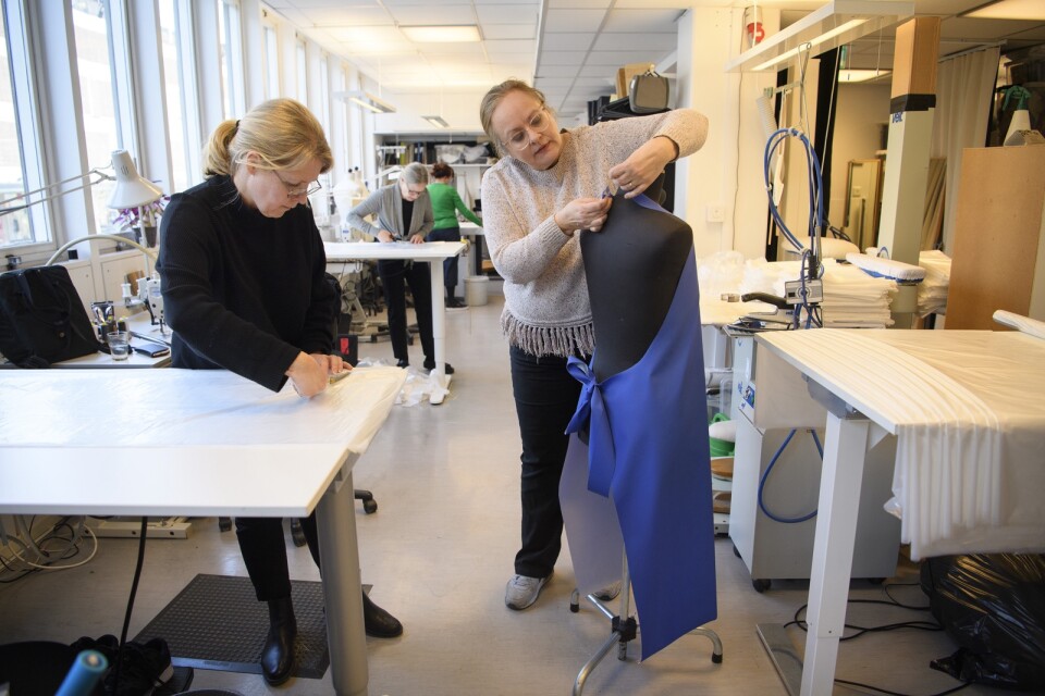 Anette Hovmark och Nancy Andreassen Peters provar ut ett skyddsförkläde.