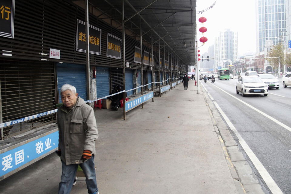 En man passerar den igenbommade marknaden i Wuhan i Kina, där utbrottet av det sarsliknande viruset tros ha börjat.
