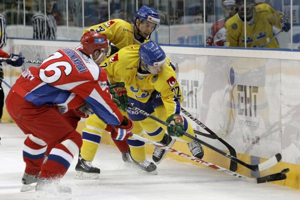 Rysslands Alexander Guskov, till vänster, och Sveriges Tobias Viklund slåss om pucken.