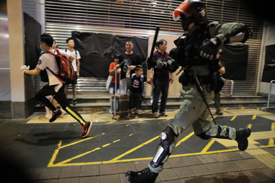 Polis jagar en demonstrant i Hongkong under söndagen.