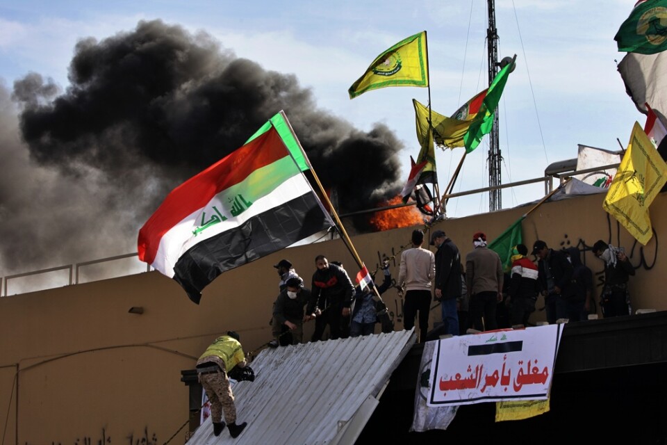 Proiranska milismedlemmar protesterade utanför USA:s ambassad i Bagdad på nyårsdagen.