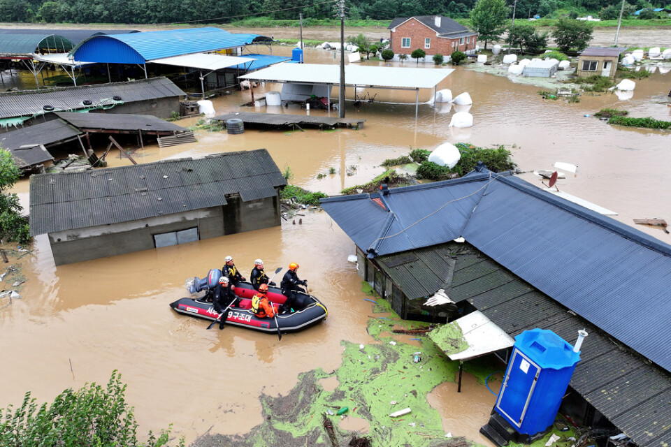 Räddningspersonal söker efter saknade personer i de översvämmade områdena.