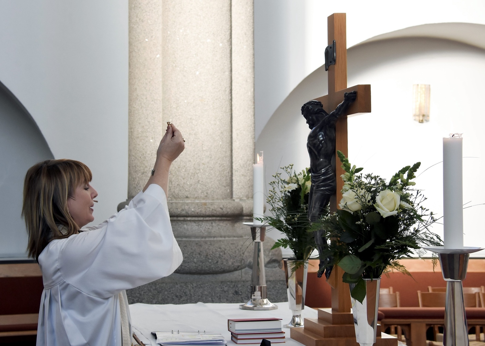Prästen Christina Liljegren välsignar ringarna innan de hamnar på brudparens fingrar.
