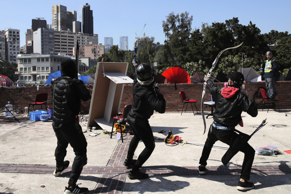 Demonstranter förbereder sig för att skjuta med pilbåge under en konfrontation med polisen vid polytekniska universitetet på söndagen.