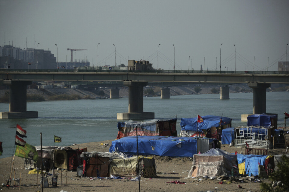 Demonstranter har slagit upp ett läger vid en bro som leder till området Gröna zonen i Iraks huvudstad Bagdad.