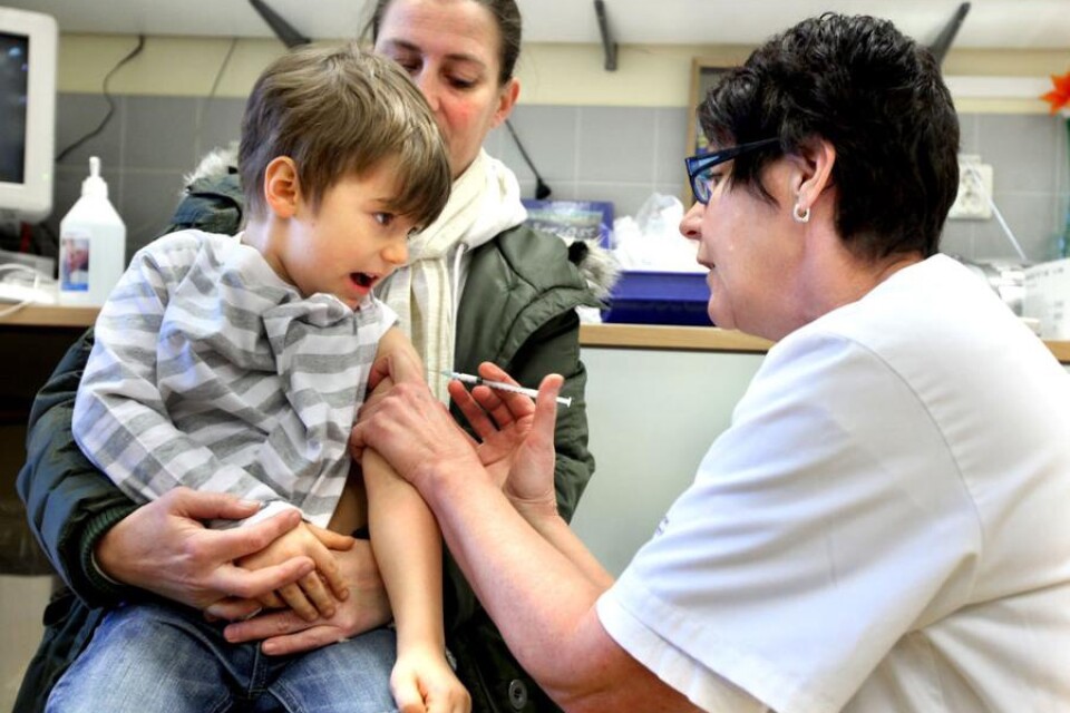 Jack Örnefjord tar plats i mamma Mias knä och låter utan protester Ann-Carin Larsson ge honom sprutan med influensa vaccin.