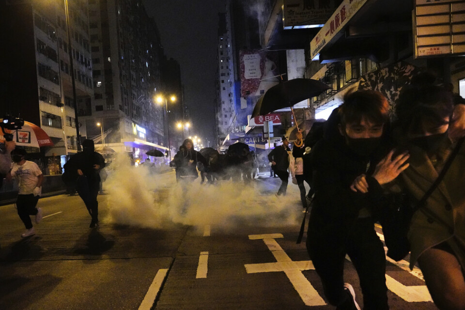 Demonstranter i Hongkong flyr undan polisens tårgas på nyårsnatten.