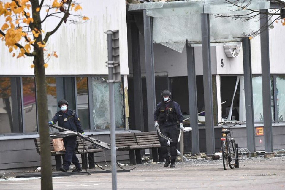 Poliser röjer upp vid den sprängda entrén till polishuset i Helsingborg på onsdagen.