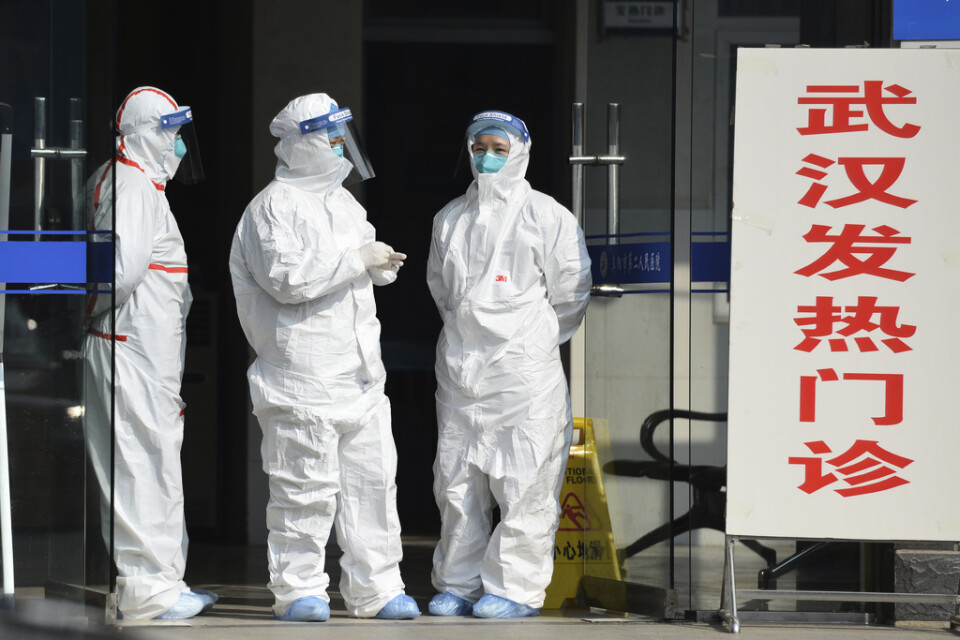 Vårdarbetare i skyddsutrustning väntar på patienter som skickats från Wuhan till Fuyang i januari 2020, i inledningen av den pandemi som skulle komma att lamslå både Kina och resten av världen.
