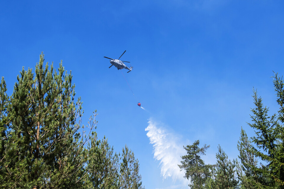En skogsbrand rasar norr om Mora. Bland annat deltar två helikoptrar i släckningsarbetet. Bilden är tagen när en helikopter vattenbombar en skogsbrand vid ett annat tillfälle.