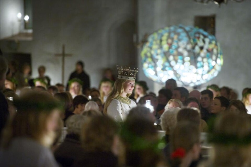 Lucia Ofelia Berg bar en krona utan ljus men med guld och pärlor under det medeltida luciafirandet.