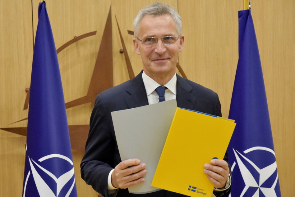 Natos generalsekreterare Jens Stoltenberg håller upp Sveriges och Finlands underskrivna anslutningsprotokoll på Natos högkvarter.