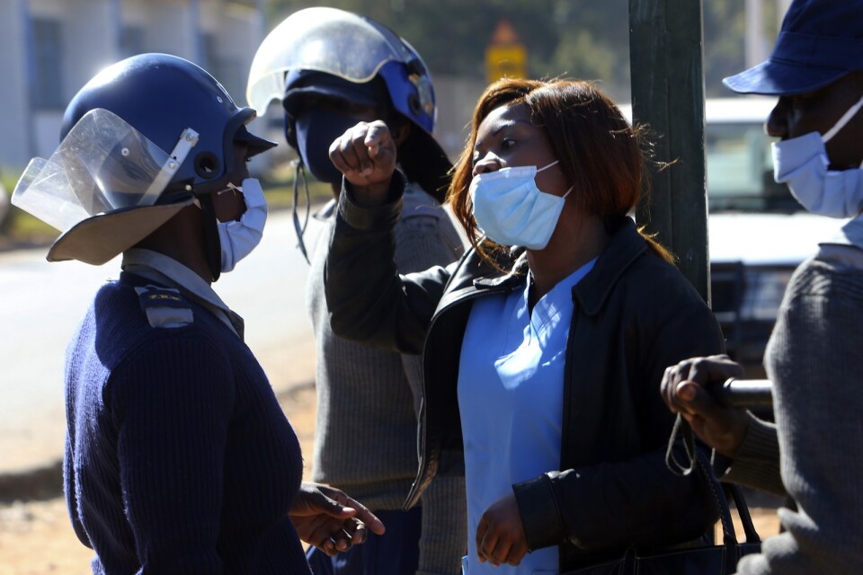 Polis griper en av de demonstrerande sjuksköterskorna i Harare.