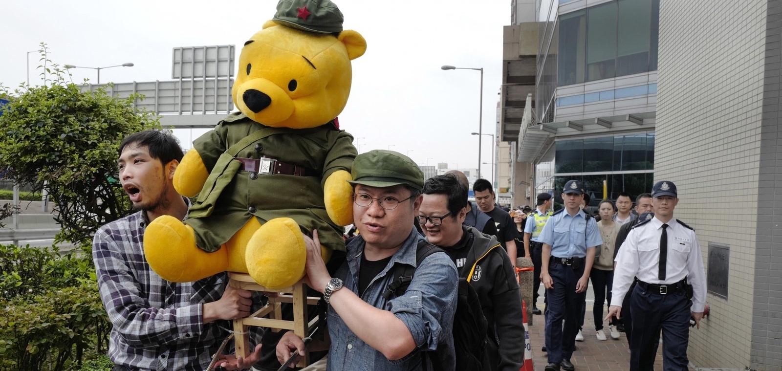 Demonstranter i Kina protesterar mot president Xi Jipping med en utklädd Nalle Puh. Foto: AP