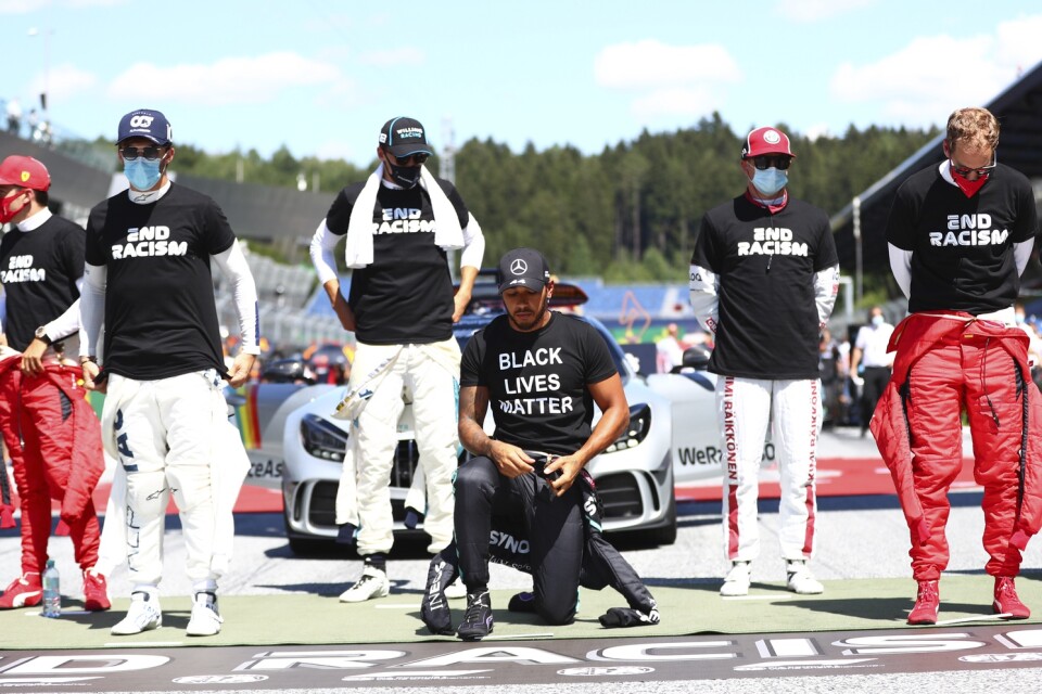 Lewis Hamilton knäböjer inför F1-premiären i Österrike.