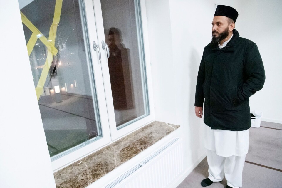 Imam Rizwan Afzal vid skotthålet i ett fönster på Mahmoodmoskén i östra Malmö på nyårsdagen.