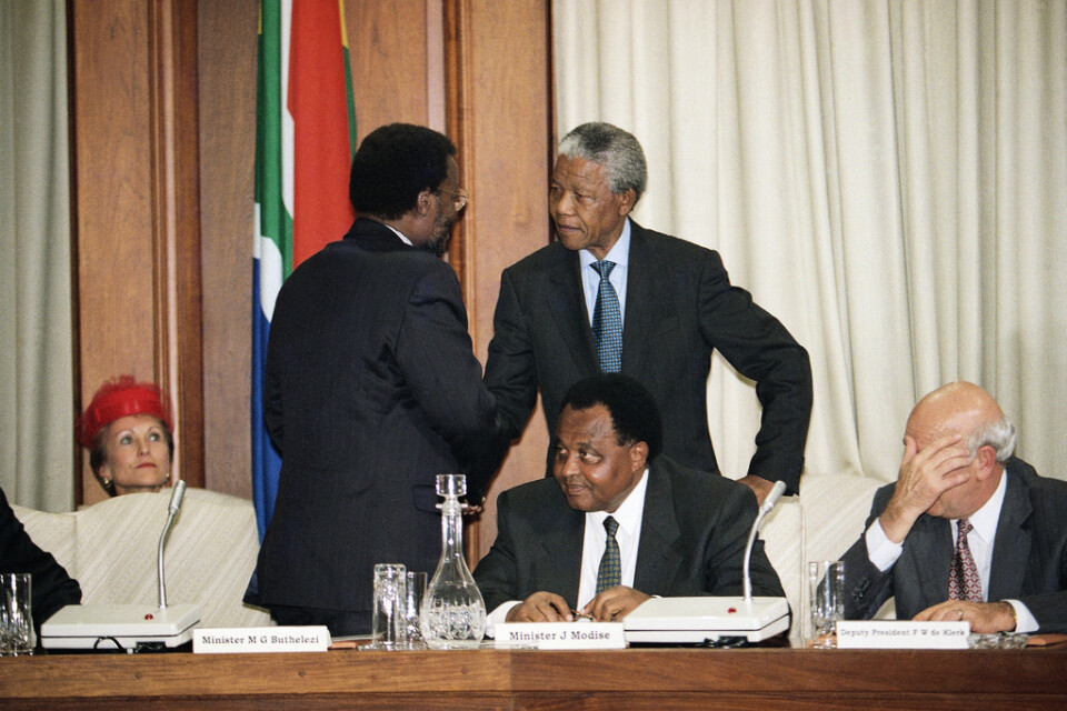 Inkhatarörelsens ledare Manosuthu Buthelezi (stående till vänster) i försoning med ANC-ledaren och Sydafrikas president Nelson Mandela 1994. Arkivbild.