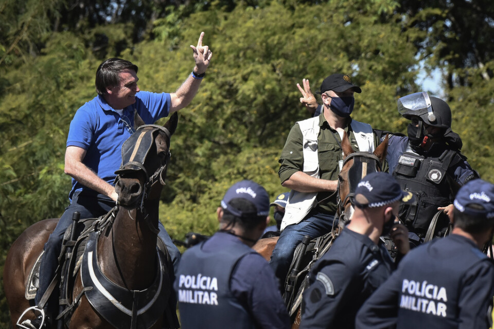 Brasiliens president Jair Bolsonaro ridande på en polishäst vid en protest utanför presidentpalatset i huvudstaden Brasília på söndagen.