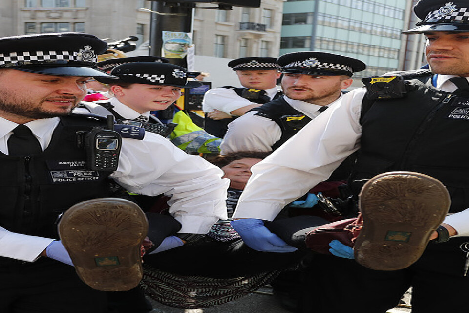 Brittiska poliser bär bort en demonstrant vid Oxford Circus. på långfredagen.