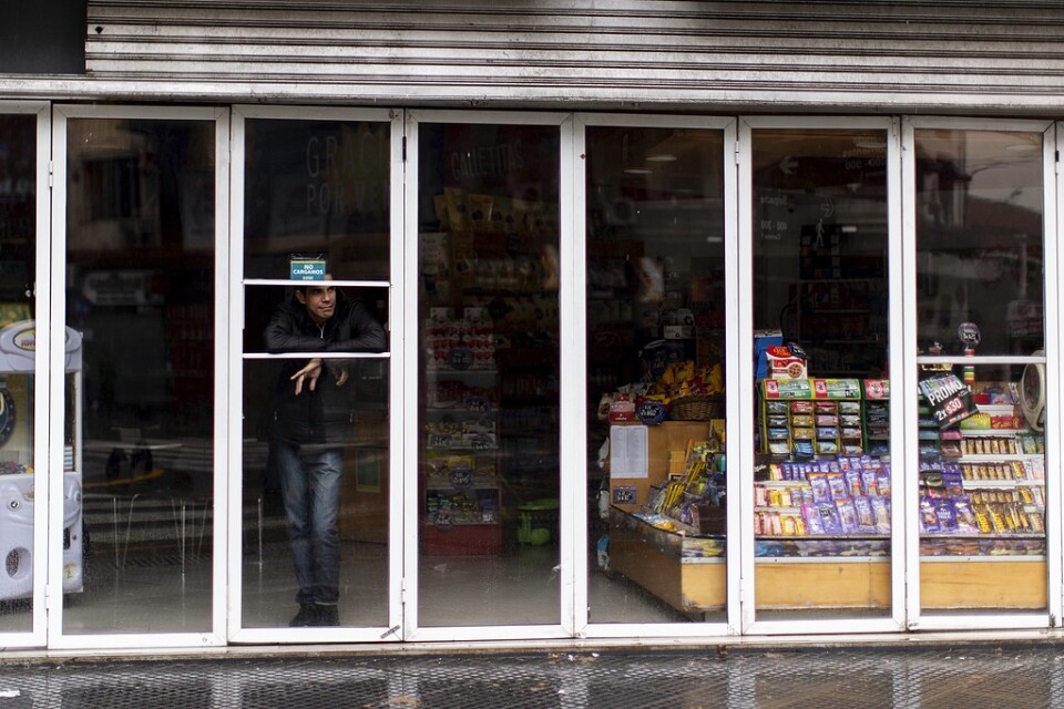 En man står inne i en nedsläckt affär i Buenos Aires i Argentina som drabbats av det omfattande strömavbrottet i Sydamerika på söndagen.