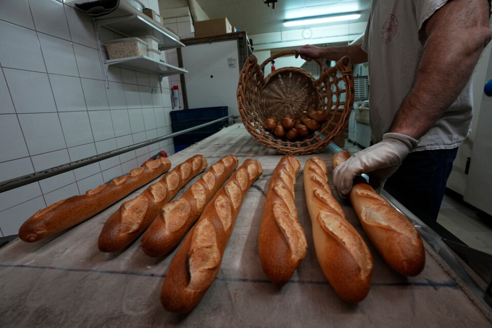 Bagaren David Buelens lägger nybakade baguetter i en korg, i ett bageri i Versailles utanför Paris. Arkivbild.