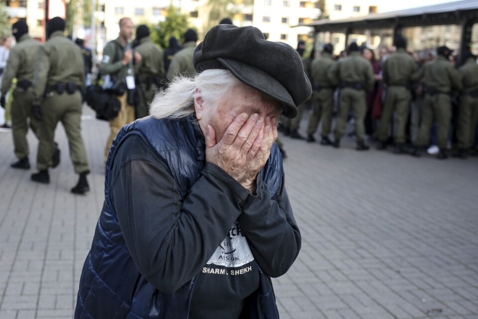 En äldre kvinna reagerar på polisens bortföranden av demonstranter under lördagens protester i Minsk, Belarus.