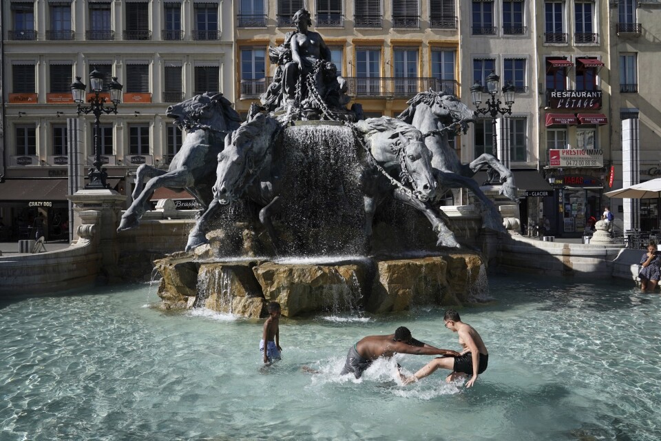 Barn leker i en fontän i franska Lyon, där temperaturerna närmar sig 40 grader.