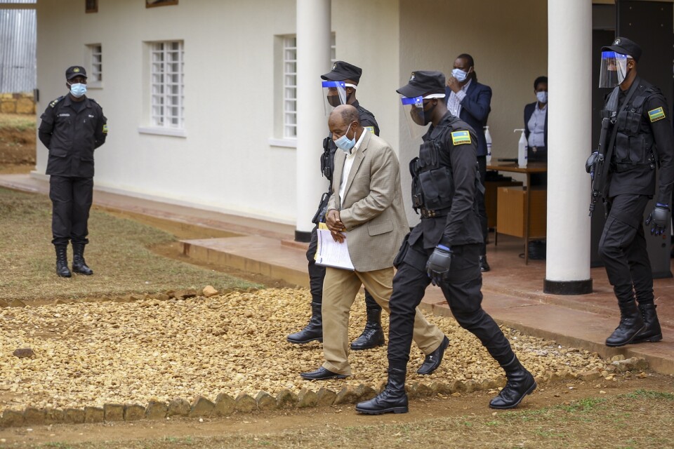 Paul Rusesabagina leds ut från rätten i handfängsel, efter måndagens delgivning av formella anklagelsepunkter.