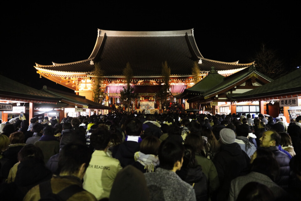 Människor samlas vid templet Sensoji i Tokyo för att tända rökelse inför det nya året.