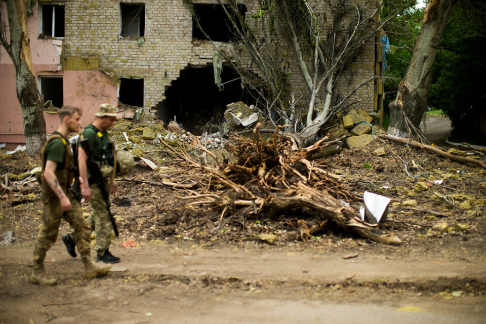 Ukrainska soldater passerar en sönderbombad byggnad i Bachmut i den nordliga delen av Donetsk i slutet av maj. Arkivbild.