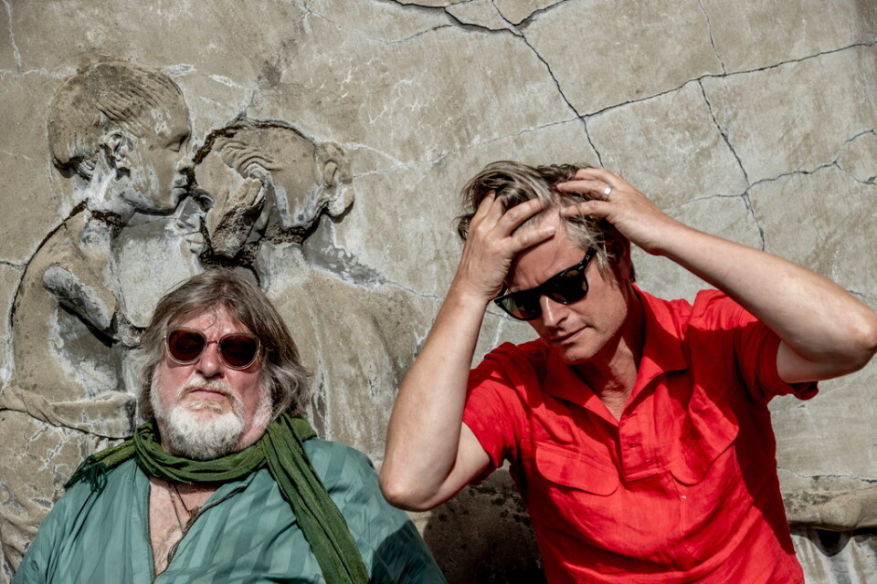 Ebbot Lundberg och Martin Hederos minns turnerandet med Oasis, sittande vid en betongtavla av konstnären Lui Hopf utanför replokalen i Göteborg.