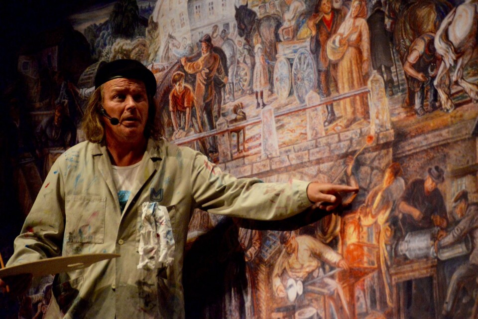 Arto Muhonen i rollen som konstnären Gunnar Theander förklarar freskmålningens motiv i en scen.