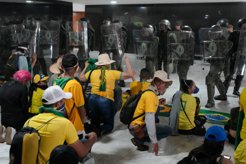 Anhängare till Brasiliens expresident Jair Bolsonaro konfronteras av kravallpolis under upploppen huvudstaden Brasília i januari 2023. Arkivbild.