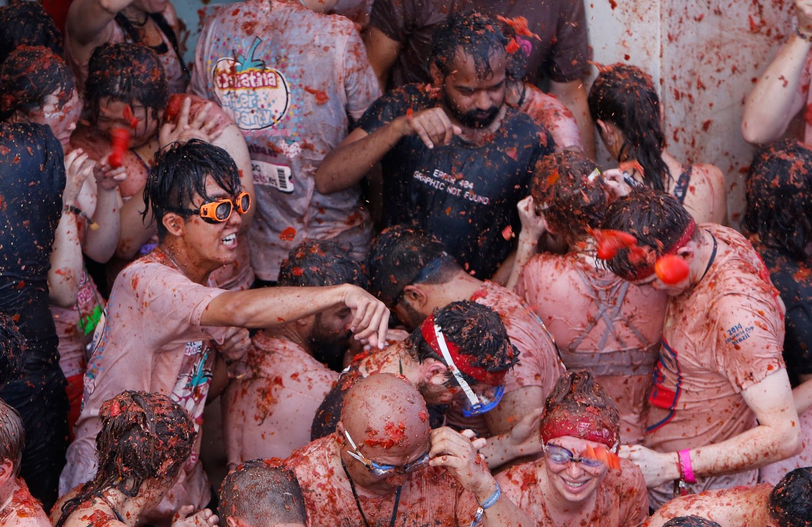 Revelers throw tomatoes at each other, during the annual "Tomatina", tomato fight fiesta, in the village of Bunol, 50 kilometers outside Valencia, Spain, Wednesday, Aug. 29, 2018. At the annual "Tomatina" battle, that has become a major tourist attraction, trucks dumped 160 tons of tomatoes for some 20,000 participants, many from abroad, to throw during the hour-long Wednesday morning festivities. (AP Photo/Alberto Saiz)