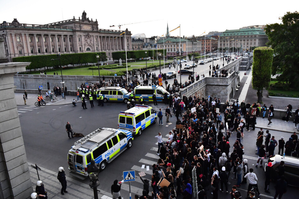 Kravallpoliser stoppar demonstranter nedanför slottet vid Norrbro i Stockholm.