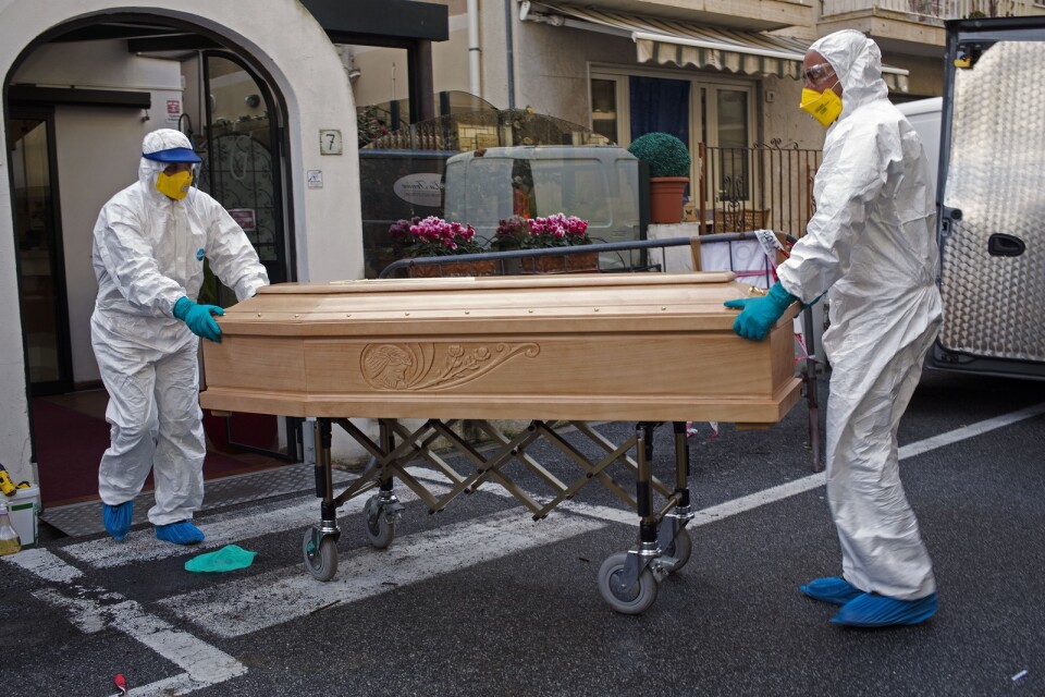 Medicinsk personal bär ut kistan för en person som avlidit i covid-19 i regionen Lombardiet i Italien. Arkivbild.