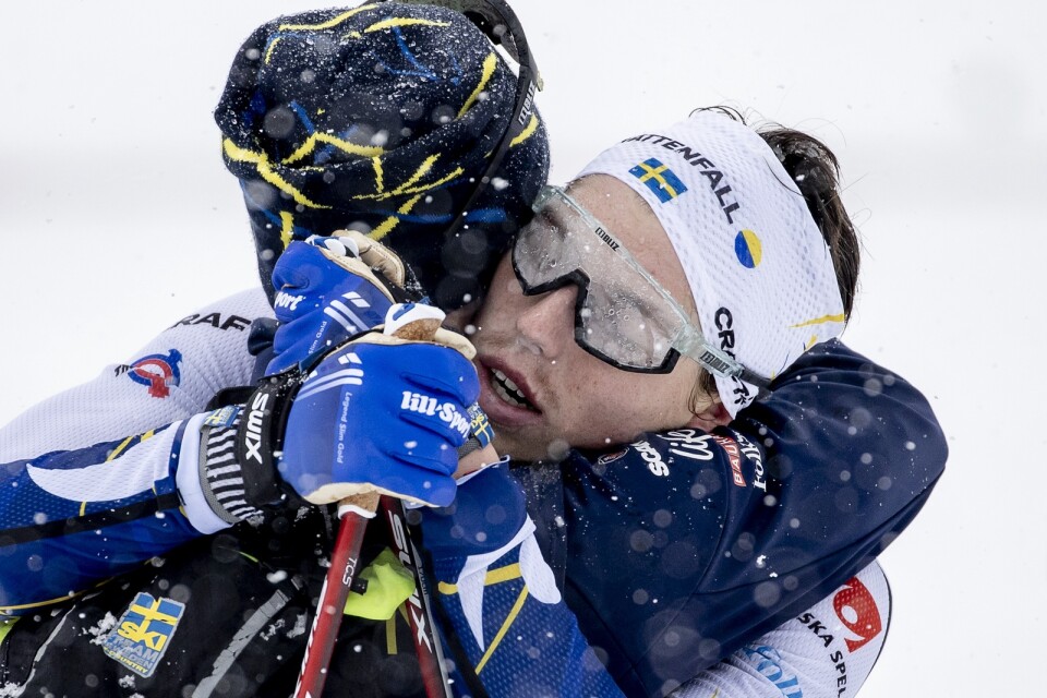 Jens Burman kramar om William Poromaa efter målgången på herrarnas stafett under skid-VM i Oberstdorf.