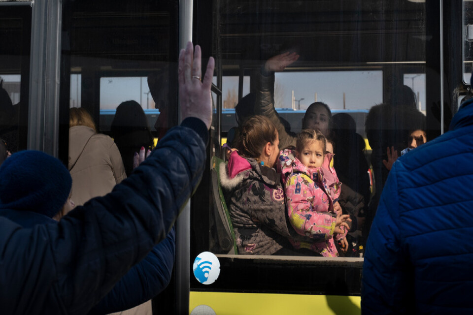 En pappa vinkar av sin familj som åker mot den polska gränsen i Lviv i mars 2022. De flesta flyktingar från Ukraina anlände i mars förra året.