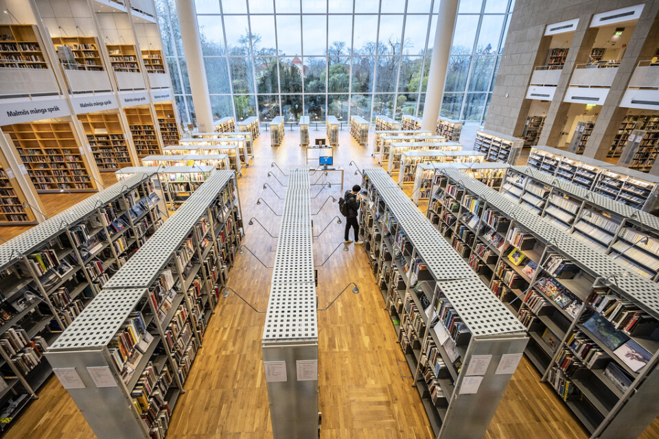 Enstaka besökare och en coronasäkrad informationsdisk på Malmö stadsbibliotek. Arkivbild.