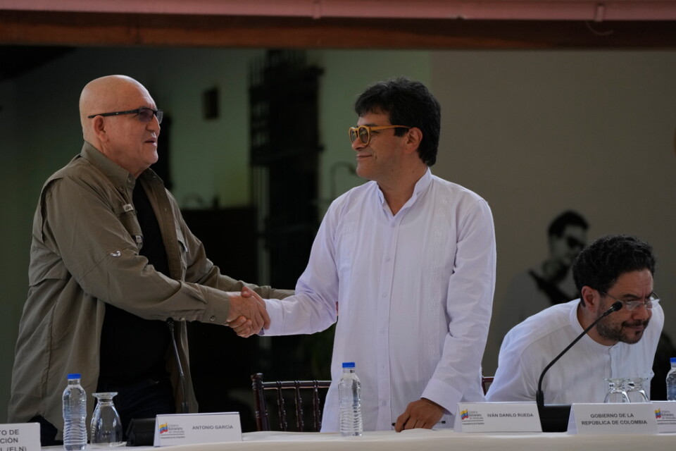 Antonio García, ledare för vänstergerillan ELN (till vänster) skakar hand med Iván Danilo Rueda som representerar den colombianska regeringen, efter att de skrivit under ett avtal om att återuppta fredssamtalen.