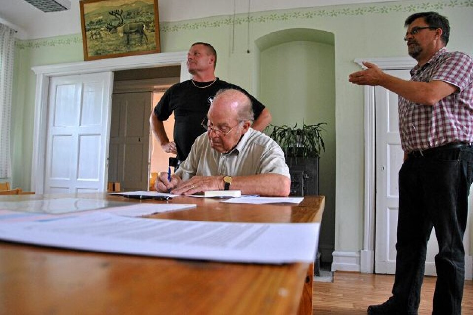 Artur Jarl skriver under sockengillets protestbrev till Eon. Per-Ola Andersson och ordförande Marcus Frennemark diskuterar strömavbrotten med en annan bybo. Arkivbild