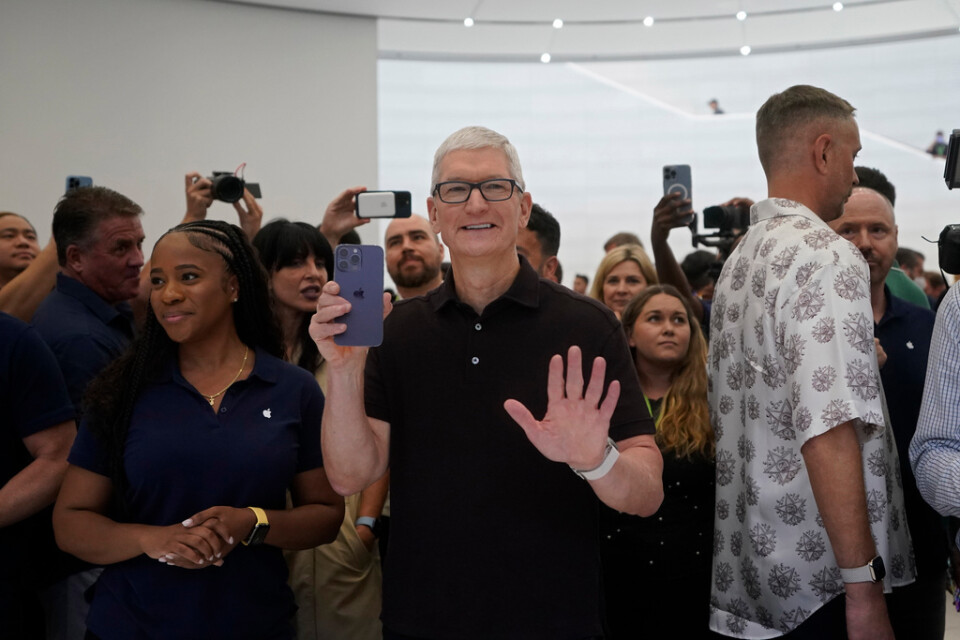 Apples vd Tim Cook med bolagets nya telefon i näven på plats i techmeckat Cupertino i Kalifornien.